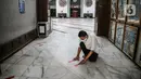 Petugas memasang tanda batas shaf di Masjid Cut Meutia, Jakarta, Kamis (30/7/2020). Masjid Cut Meutia akan menggelar Salat Idul Adha esok hari dengan menerapkan protokol kesehatan pencegahan Covid-19. (Liputan6.com/Faizal Fanani)