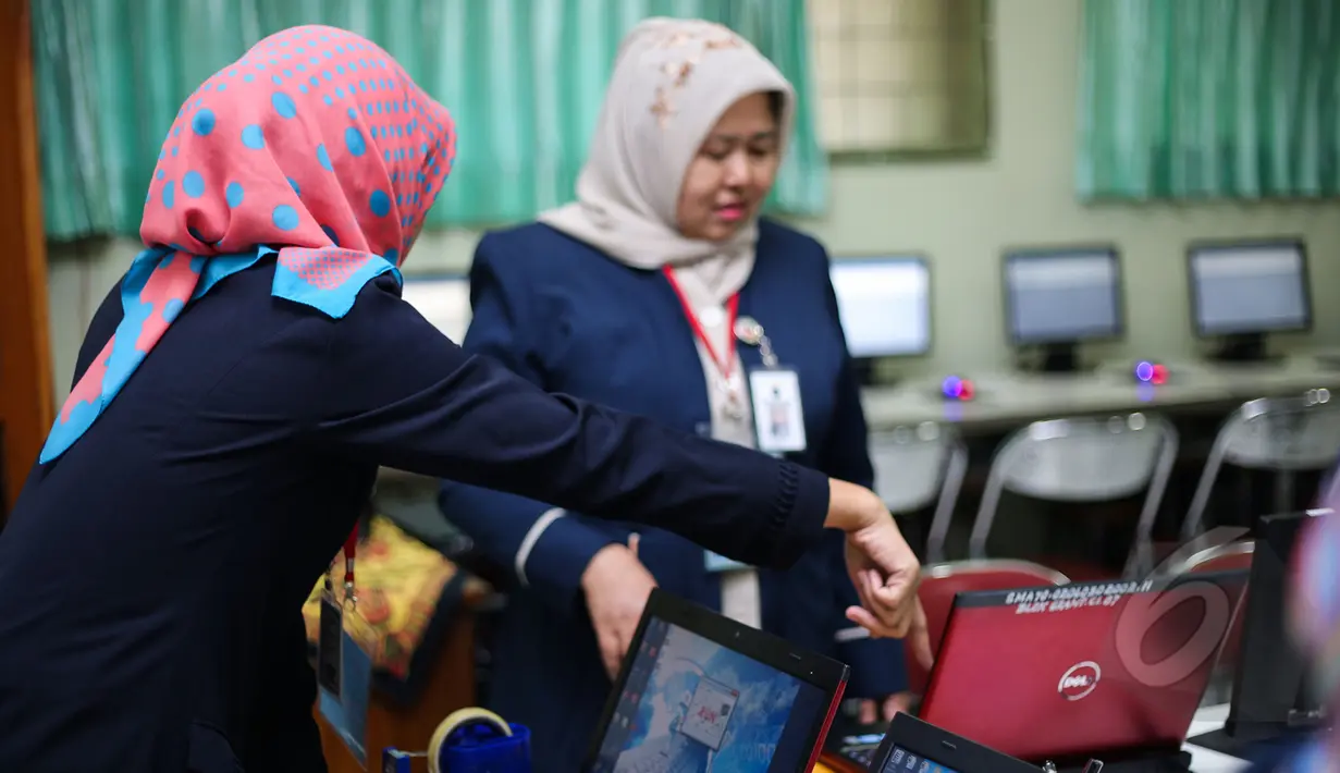 Sejumlah Guru mempersiapkan komputer untuk ujian nasional (UN) di SMA 70, Jakarta, Senin (13/4/2015). Sebanyak 585 dari 70 ribu sekolah menjadi percontohan menjalankan ujian nasional berbasis komputer di seluruh Indonesia.  (Liputan6.com/Faizal Fanani)