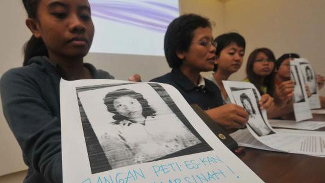 Seorang aktivis menuliskan pesan di foto Marsinah saat konferensi pers 
