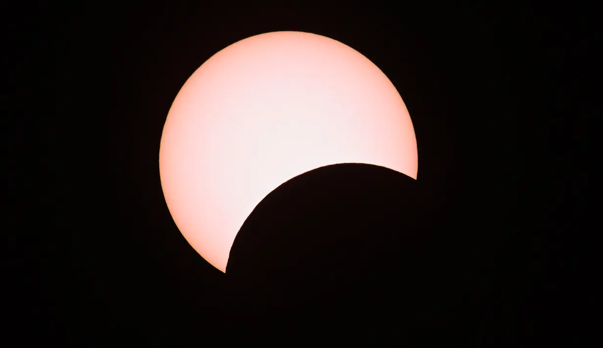 Bulan menutupi sebagian matahari selama gerhana matahari cincin (Annular Solar Eclipse) yang terlihat dari Mandalay di Myanmar, Minggu (21/6/2020). Sebagian penduduk Bumi bisa menyaksikan fenomena langka, Gerhana Matahari Cincin. (Ye Aung THU / AFP)
