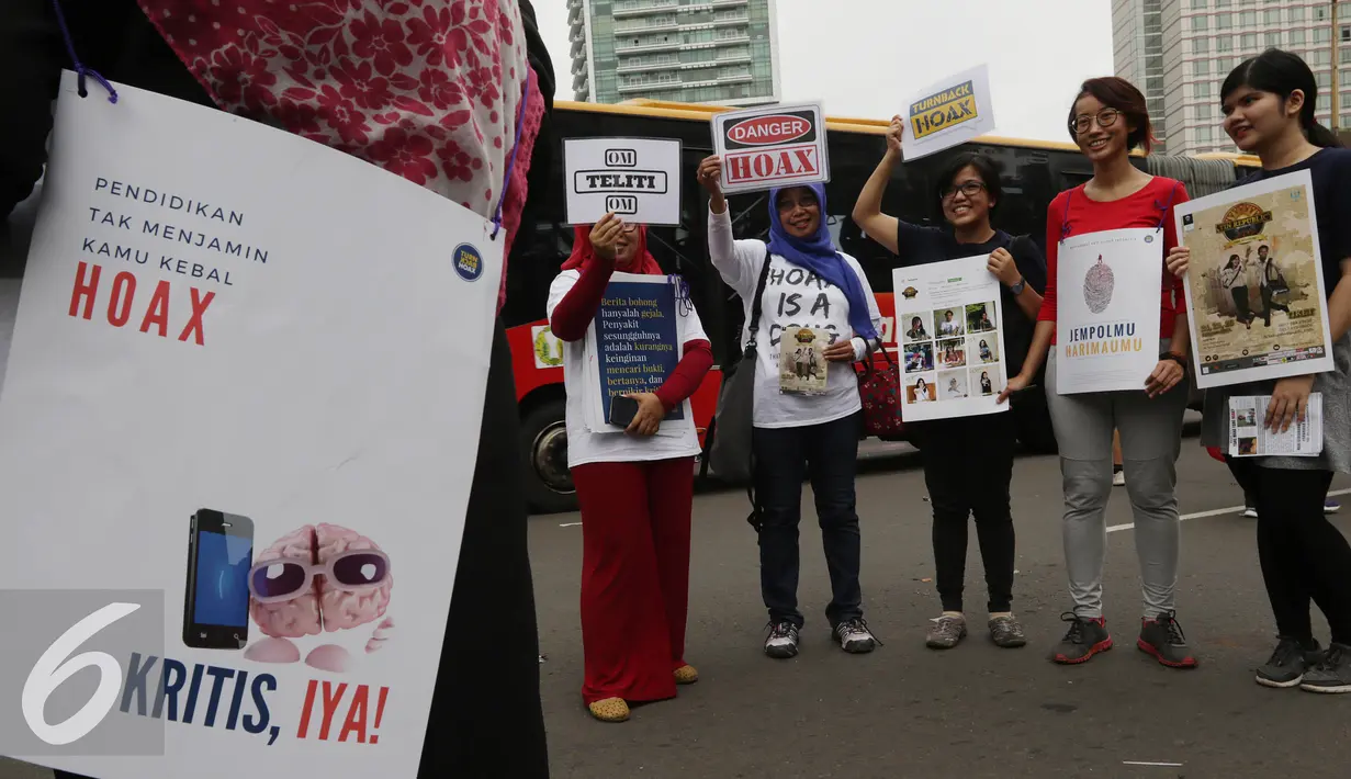 Masyarakat Anti Fitnah Indonesia (Mafindo) menunjukan poster di hari bebas kendaraan bermotor di kawasan Thamrin, Jakarta, Minggu (22/1). Aksi tersebut digelar untuk menghimbau masyarakat terkait berita hoax yang marak beredar. (Liputan6.com/JohanTallo)