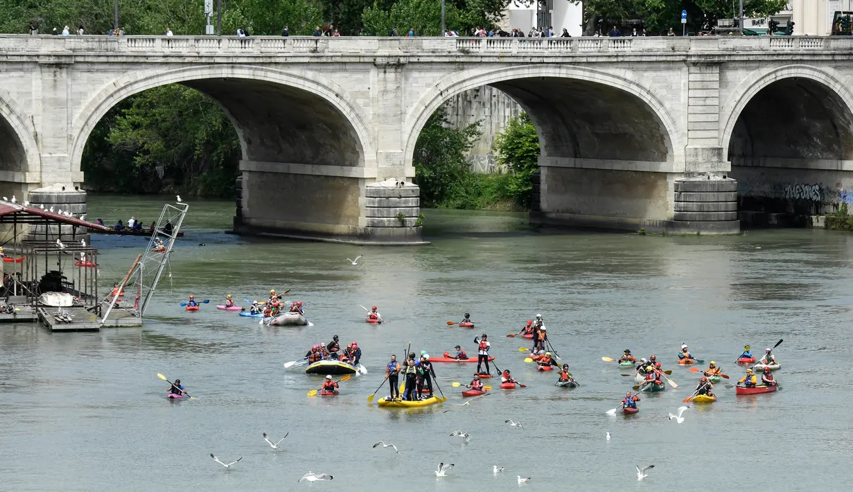 Sejumlah peserta mendayung kanonya saat mengikuti International Tiber Canoe Descent di sungai Tiber di Roma, Italia (5/1). Olahraga kano ini terbagi menjadi beberapa jenis,  antara lain adalah Sprin, Slalom, dan Polo. (AFP Photo/Andreas Solaro)