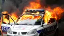 Sebuah mobil polisi terbakar saat demonstrasi buruh di Paris, Prancis (18/5). Demo buruh tersebut menentang kekerasan polisi dan melawan reformasi hukum yang berakhir bentrok dengan polisi. (REUTERS / Charles Platiau)