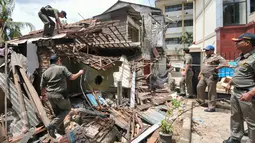 Anggota Satpol PP merobohkan bangunan rumah petak tepat di samping Kantor Kelurahan Rawajati, Pancoran, Jakarta, Selasa (22/12). Empat rumah petak dibongkar oleh Satpol PP karena berdiri di atas lahan milik Pemprov DKI Jakarta. (Liputan6.com/Yoppy Renato)