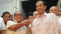 Jokowi dan ARB saling bergenggam tangan sebagai simbol kesamaan visi tentang keberpihakan terhadap ekonomi kerakyatan, Pasar Gembrong, Jakarta Pusat, Selasa (14/5/2014) (Liputan6.com/Herman Zakharia)