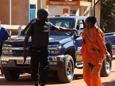 Pasukan keamanan Mali mengevakuasi dua wanita yang menjadi sandera di Hotel Radisson Blu di Bamako, Jumat (20/11). Kelompok militan Islam menyerbu hotel mewah tersebut dan  menyandera lebih dari 100 orang tamu serta staf hotel. (AFP PHOTO/Habibou Kouyate)