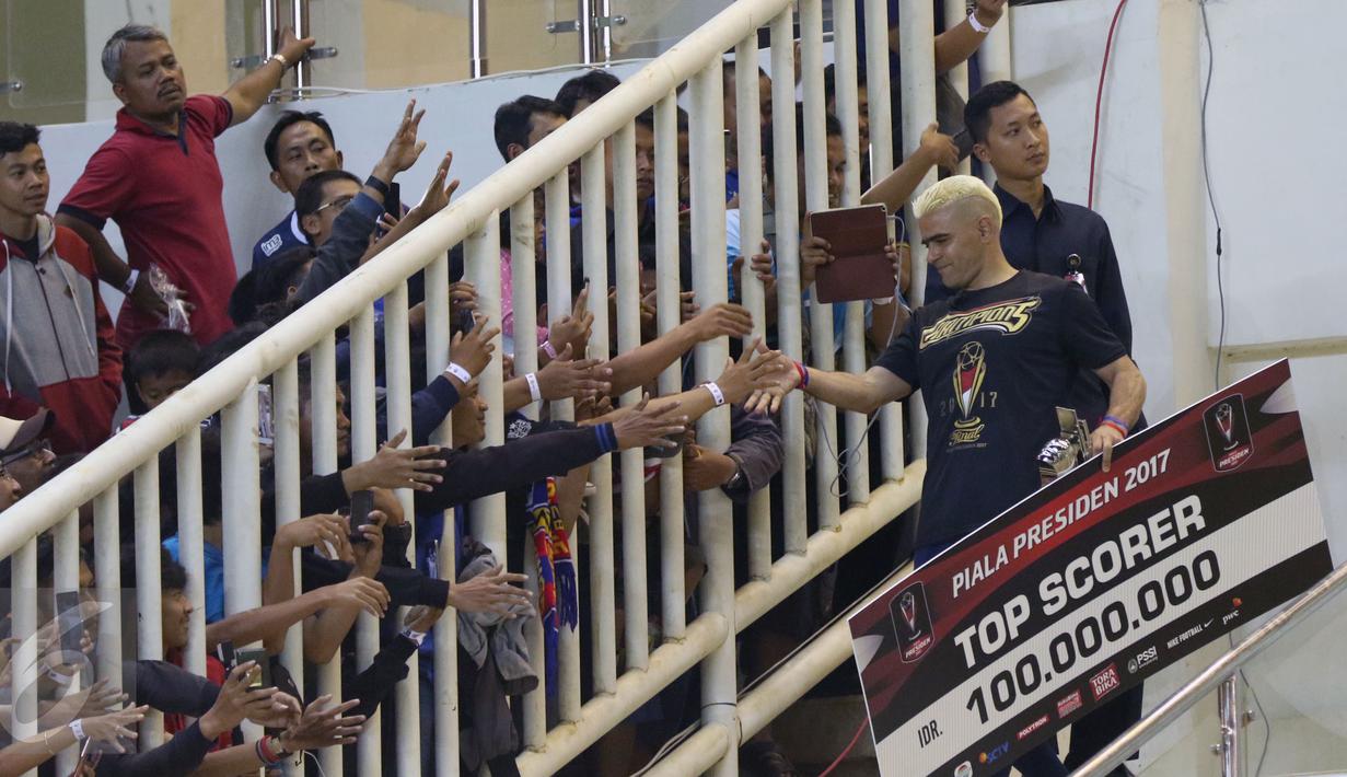 Pemain Arema FC, Cristian Gonzales menyalami suporter usai menerima trofi pencetak gol terbanyak usai laga final Piala Presiden 2017 di Stadion Pakansari, Minggu (12/3). Cristian Gonzales berhasil mencetak 11 gol. (Liputan6.com/Helmi Fithriansyah)