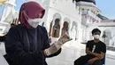 Seorang petugas kesehatan menyiapkan dosis vaksin corona COVID-19 Sinovac saat pelaksanaan vaksinasi di Masjid Raya Baiturrahman, Banda Aceh, Aceh, Selasa (7/9/2021). (CHAIDEER MAHYUDDIN/AFP)