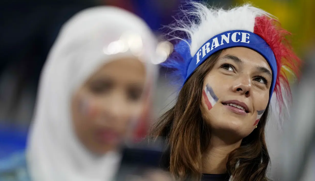 Suporter wanita Prancis saat menghadiri pertandingan melawan Denmark pada laga Piala Dunia di Stadion 974, Qatar, Sabtu (26/11/2022). (AP/Christophe Ena)