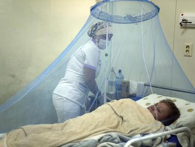 Perawat Liz Cabanas merawat seorang pria yang terinfeksi chikungunya di Rumah Sakit Clinicas di San Lorenzo, Paraguay, Jumat (3/3/2023). Pengawasan Kesehatan menyatakan bahwa dalam tiga minggu terakhir lebih dari 1200 kasus penyakit yang ditularkan oleh nyamuk telah terjadi. telah dilaporkan. (AP Photo/Jorge Saenz)