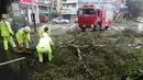 Pemadam kebakaran memidahkan pohon dijalan akibat angin kencang Topan Soudelor di Taipei, Taiwan, (8/8/2015). Empat orang tewas akibat peristiwa angin kencang Topan Soudelor dan hujan deras.  (REUTERS/Pichi Chuang)