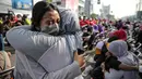 Sejumlah anak memeluk ibunya pada aksi cuci kaki ibu massal di Jakarta, Minggu (18/12/2022). Aksi yang diikuti sebanyak ratusann peserta itu bertujuan untuk meningkatkan rasa cinta kasih kepada ibu , khususnya dalam rangka memperingati Hari Ibu. (Liputan6.com/Faizal Fanani)