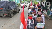 Sejumlah anak pengajian melakukan pawai di Jalan Raya Tapos, Depok, Jawa Barat, Kamis (22/10/2020). Pengajian Kampung Tapos menggelar pawai menyambut Hari Santri Nasional 2020 yang diperingati setiap tanggal 22 Oktober. (Liputan6.com/Herman Zakharia)