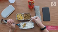 Karyawan menggunakan alat makan pribadi saat menikmati makan siang di ruang istirahat kantor Suntory Garuda, Jakarta, Senin (8/8/2020). Suntory Garuda menerapkan protokol Kesehatan, salah satunya kapasitas karyawan hanya dibolehkan sebanyak 50 persen. (Liputan6.com/Herman Zakharia)