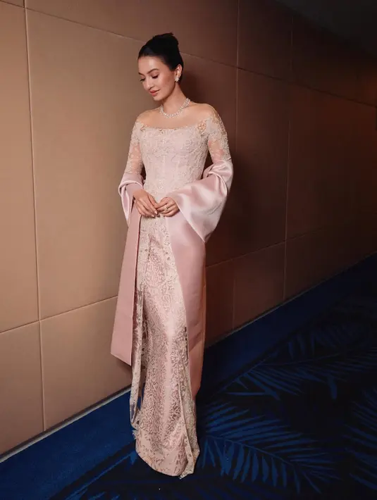 Siluet lace yang feminin dipadukan dengan selendang satin memberi kesan lembut sekaligus elegan. Makeup soft glam bernuansa pink dengan sentuhan lip gloss glossy membuat penampilannya terlihat fresh dan sophisticated. Tak ketinggalan, perhiasan Chopard yang dikenakannya semakin mempertegas aura glamor kelas dunia.
