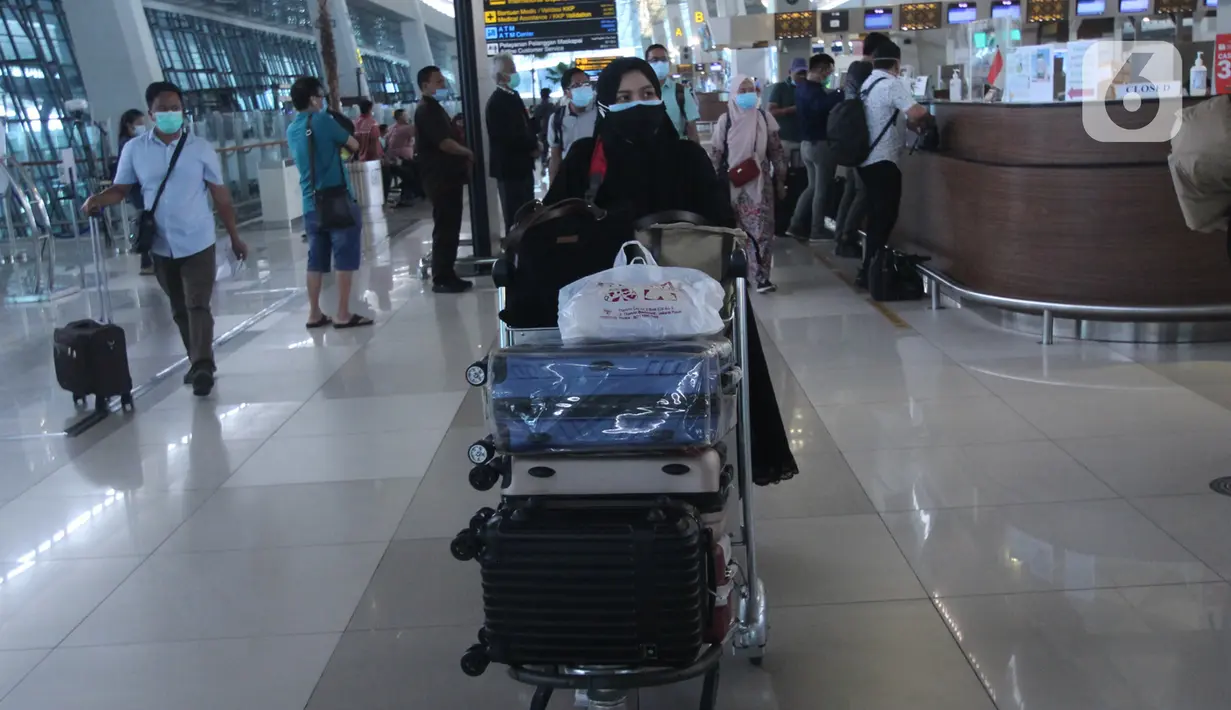 Penumpang pesawat udara membawa barang bawaan di Terminal 3 Bandara Soekarno Hatta, Tangerang, Banten, Jumat (18/12/2020). PT Angkasa Pura II (Persero) atau AP II memprediksi lalu lintas sebanyak 2,1 juta penumpang pada periode angkutan Natal dan Tahun Baru 2021. (Liputan6.com/Angga Yuniar)