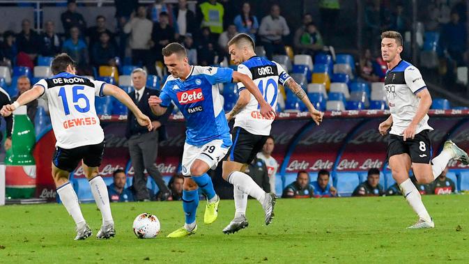 Pemain Atalanta, Marten de Roon berebut bola dengan striker Napoli, Arkadiusz Milik dalam laga pekan kesepuluh Liga Italia di Stadion San Paolo, Naples, Rabu (30/10/2019). Napoli dipaksa bermain imbang 2-2 oleh Atalanta. (Ciro Fusco/ANSA via AP)