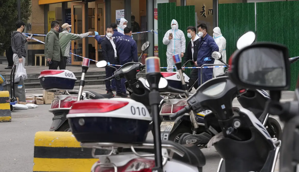 Pekerja mengontrol akses menuju komunitas yang lockdown di Beijing, Minggu (13/3/2022). Pihak berwenang memperketat kontrol akses ke Shanghai setelah jumlah kasus baru covid-19 di timur laut China meningkat tiga kali lipat pada hari Minggu. (AP Photo/Ng Han Guan)