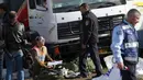 Petugas kepolisian melakukan penyelidikan di lokasi serangan truk yang menabrak sejumlah tentara Israel di sebuah tempat wisata di Yerusalem, Minggu (8/1). Supir truk tersebut langsung ditembak mati paska melakukan aksinya. (AP Photo/Mahmoud Illean)