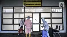 Petugas menyemprotkan disinfektan kepada tim medis dan pasien sebelum memasuki Pusat Rawat Isolasi Khusus Mandiri di Stadion Patriot Candrabhaga, Bekasi, Rabu (23/9/2020). Dinas Kesehatan Bekasi menyiapkan 57 tempat tidur di rumah sakit darurat itu untuk pasien Covid-19. (merdeka.com/Iqbal Nugroho)