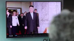 Orang-orang berjalan di dekat sebuah layar yang melaporkan peluncuran rudal Korea Utara, di Osaka, Jepang (29/5). Rudal jarak dekat itu terbang selama enam menit dan akhirnya mendarat di Laut Jepang. (Meika Fujio / Kyodo News via AP)