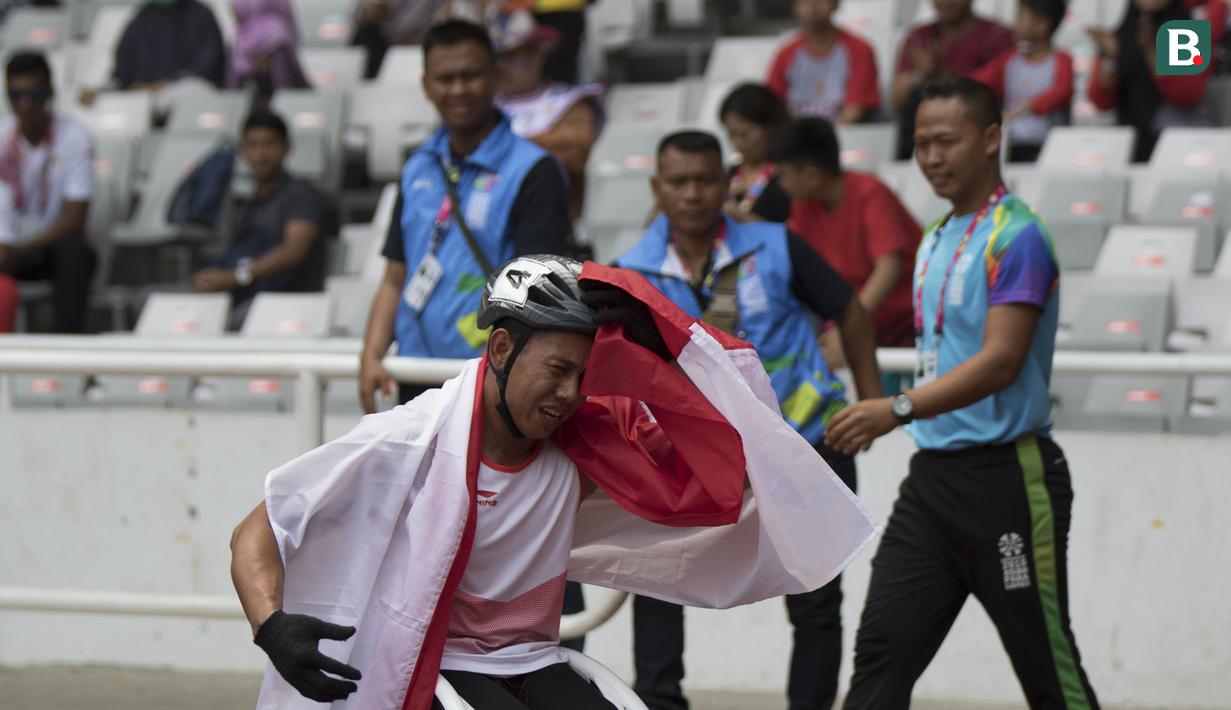 Pebalap kursi roda Indonesia, Jaenal Aripin, melakukan selebrasi usai meraih medali perak pada Asian Para Games cabang atletik nomor balap kursi roda 200 meter T 54 di SUGBK, Jakarta, Jumat (12/10). (Bola.com/Vitalis Yogi Trisna)