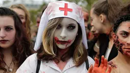 Seorang wanita mengenakan kostum suster bergaya zombie berpose saat mengikuti "Zombie Walk" di Paris, Prancis (7/10). (AFP Photo/Thomas Samson)