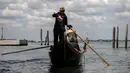 Perempuan yang tergabung dalam Row Venice menawarkan pengalaman belajar mendayung gondola di sebuah kanal di Venesia, Italia pada 16 Mei 2019. Pengalaman ini bisa dimiliki dengan sekitar Rp 1,37 juta per gondola selama 90 menit untuk empat orang yang dimulai pukul 10.00 pagi. (MARCO BERTORELLO/AFP)