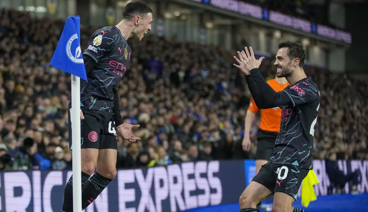 Pemain Manchester City, Phil Foden, melakukan selebrasi bersama Bernardo Silva setelah mencetak gol ke gawang Brighton & Hove Albion  dalam duel tunda pekan ke-29 Liga Inggris 2024, Jumat (26/4/2024). (AP Photo/Kin Cheung)