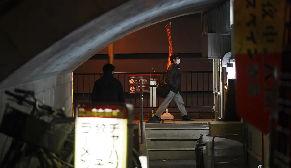 Orang-orang berjalan melewati sebuah restoran di Tokyo(7/1/2021). Ibu kota juga mengumumkan rekor 2.447 kasus Virus Corona baru pada Kamis, naik dari catatan 1.591 pada hari sebelumnya, kata pemerintah metropolitan. (AP Photo/Eugene Hoshiko)