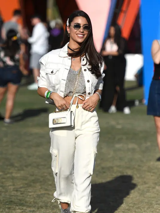 Pengunjung wanita tersenyum saat menghadiri Coachella Music & Arts Festival 2019 di Indio, California (14/4). Festival Coachella ini sudah ada sejak tahun 1999. (AFP Photo/Frazer Harrison)