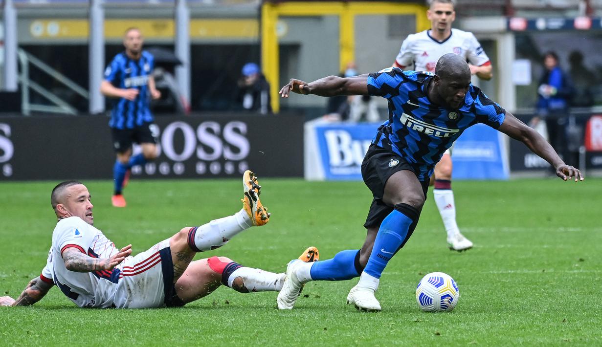 Striker Inter Milan, Romelu Lukaku lolos dari tekel yang dilakukan gelandang Cagliari, Radja Nainggolan dalam laga lanjutan Liga Italia 2020/2021 pekan ke-30 di San Siro Stadium, Milan, Minggu (11/4/2021). Inter Milan menang 1-0 atas Cagliari. (AFP/Alberto Pizzoli)
