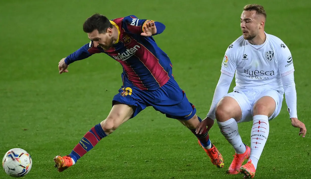 Pemain Barcelona Lionel Messi (kiri) memperebutkan bola dengan pemain Huesca Javier Ontiveros pada pertandingan Liga Spanyol di Stadion Camp Nou, Barcelona, Spanyol, Senin (15/3/2021). Barcelona menang 4-1.  (LLUIS GENE/AFP)