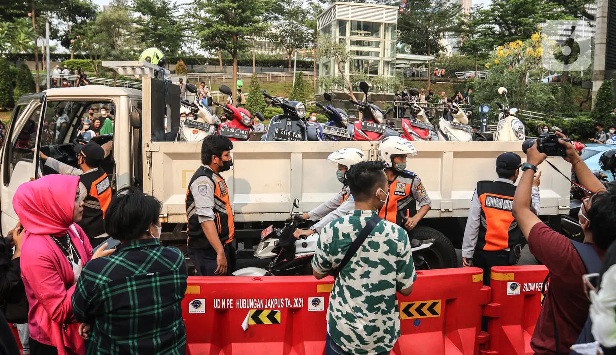 Sebuah truk mengangkut sejumlah motor yang terjaring razia parkir liar  di lokasi Citayam Fashion Week, kawasan Stasiun Dukuh Atas, Sudirman, Selasa (26/7/2022). Satpol PP dan Dinas Perhubungan (Dishub) DKI Jakarta mengamankan sebanyak 16 sepeda motor yang terpakir secara liar. (Liputan6.com/Faizal Fanani)