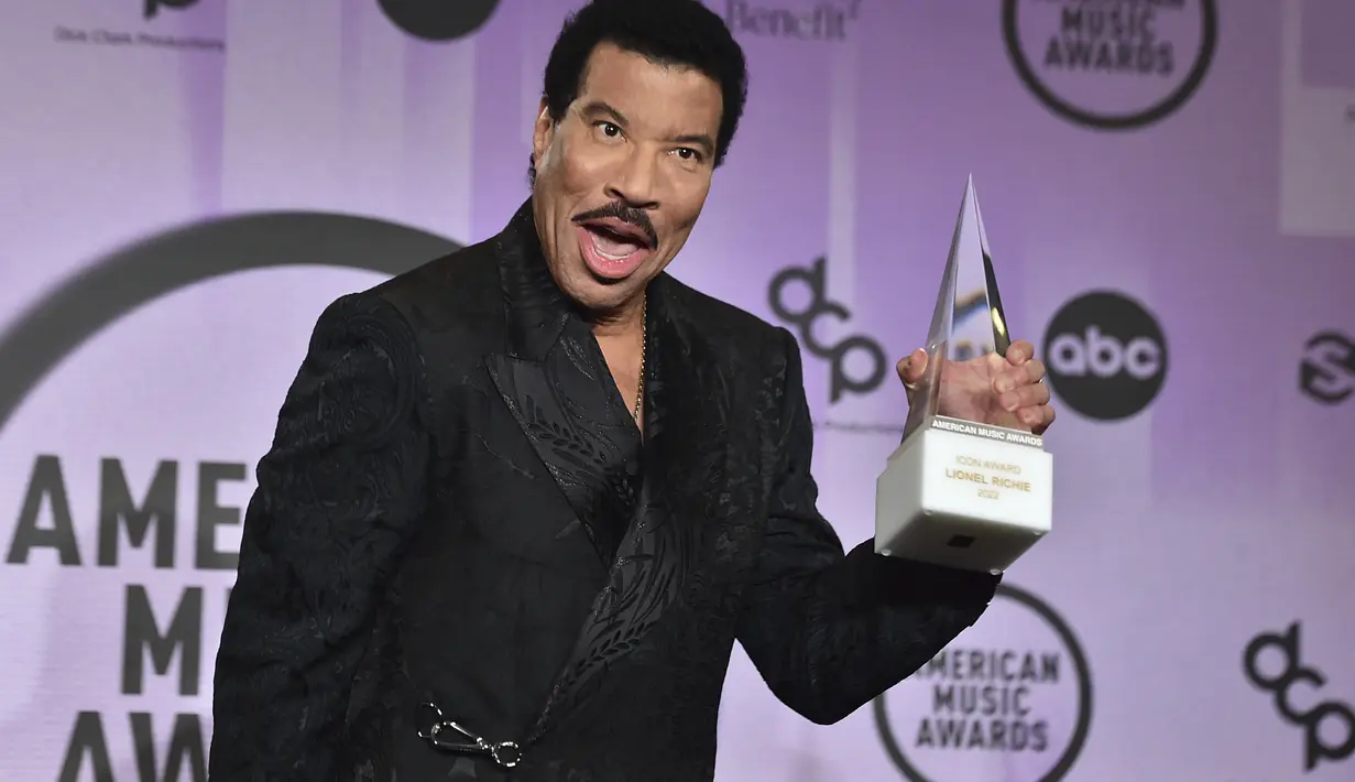 Lionel Richie berpose dengan penghargaan Icon Award di American Music Awards di Microsoft Theater di Los Angeles pada Senin (21/11/2022). Richie juga berterima kasih kepada teman-teman yang telah menjadi pendukungnya selama ini. Termasuk para penyanyi muda yang turut hadir di American Music Awards tahun ini. (AP Photo/Chris Pizzello)