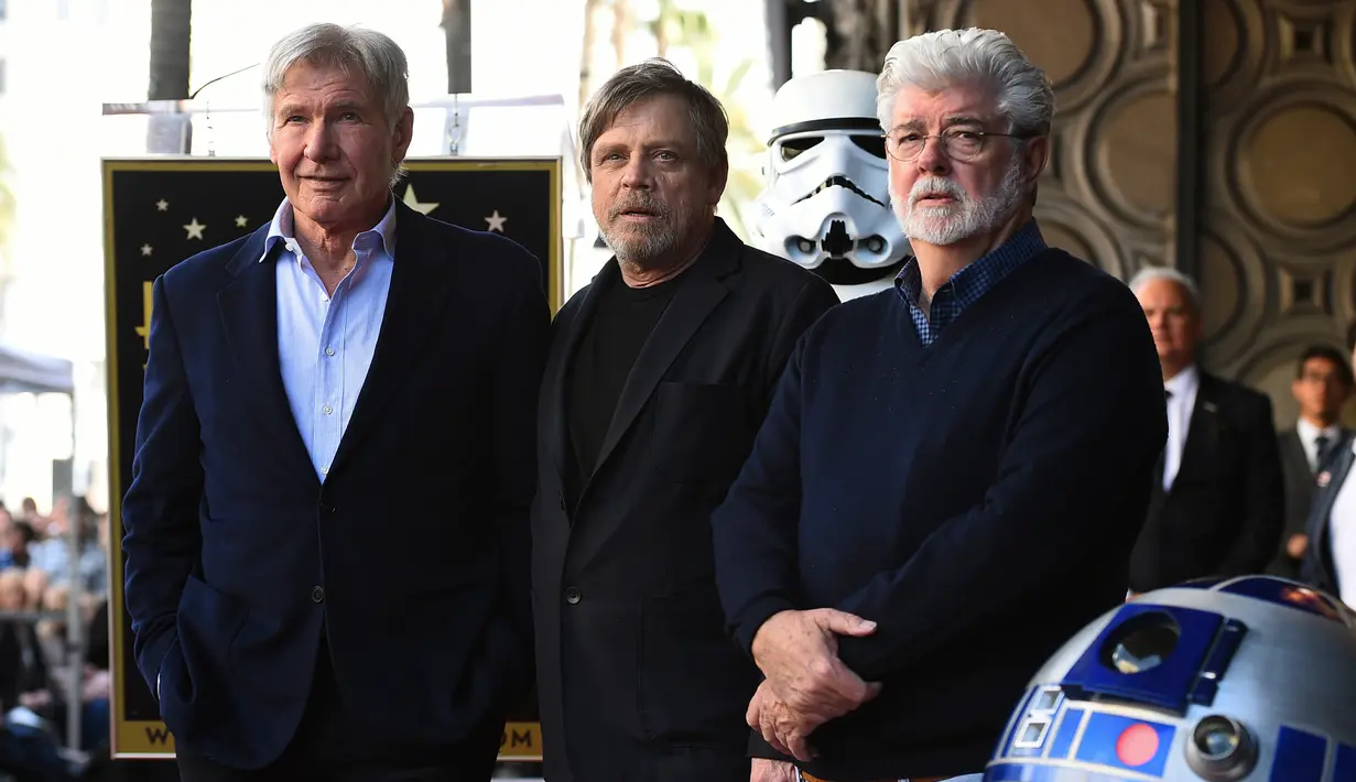Mark Hamill (tengah) berfoto bersama Harrison Ford (kiri) dan George Lucas (kanan) saat dianugerahi Hollywood Walk of Fame di Los Angeles (8/3). Yang menarik, seremoni acara dilakukan dengan tema Star Wars. (Jordan Strauss / Invision / AP)