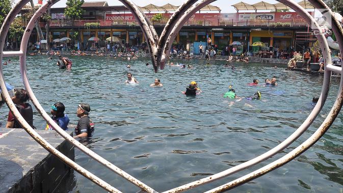 Pengunjung menikmati wisata air di kolam renang Umbul Ponggok, Desa Polanharjo, Klaten, Jawa Tengah, Minggu (30/9). Tiket masuk Umbul Ponggok sebesar Rp 15 ribu di hari biasa dan Rp 30 ribu di akhir pekan atau hari libur nasional. (Liputan6.com/Gholib)