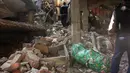 Sejumlah orang mengevakuasi barang yang masih bisa diselamatkan dari sebuah bangunan yang rusak di Imphal pasca gempa 6,7 SR yang mengguncang timur laut India, Senin (4/1). Delapan orang tewas dan lebih dari 100 luka-luka akibat gempa. (AFP PHOTO/STR)