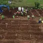 Foto udara memperlihatkan suasana pemakaman jenazah dengan protokol COVID-19 di area khusus TPU Srengseng Sawah, Jagakarsa, Jakarta, Kamis (14/1/2021). TPU Srengseng Sawah mulai menerima pemakaman jenazah dengan protokol COVID-19 sejak Selasa (12/1) lalu. (Liputan6.com/Helmi Fithriansyah)