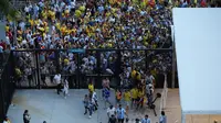 Penonton menerobos pagar Hard Rock Stadium Miami dalam laga final Copa America antara Timnas Argentina kontra Timnas Kolombia, Senin (15/7/2024). Kick off pertandingan pun harus ditunda hampir satu setengah jam. (AFP).
