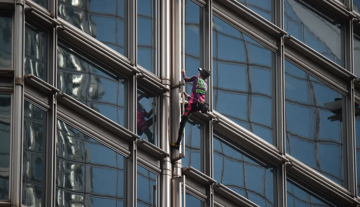 Alain Robert yang dijuluki 'French Spiderman' memanjat gedung pencakar langit Cheung Kong Center di Hong Kong, Jumat (16/8/2019). Pria berusia 57 tahun tersebut memanjat Cheung Kong Center dalam kondisi panas dan lembab pada Jumat pagi. (Lillian SUWANRUMPHA/AFP)