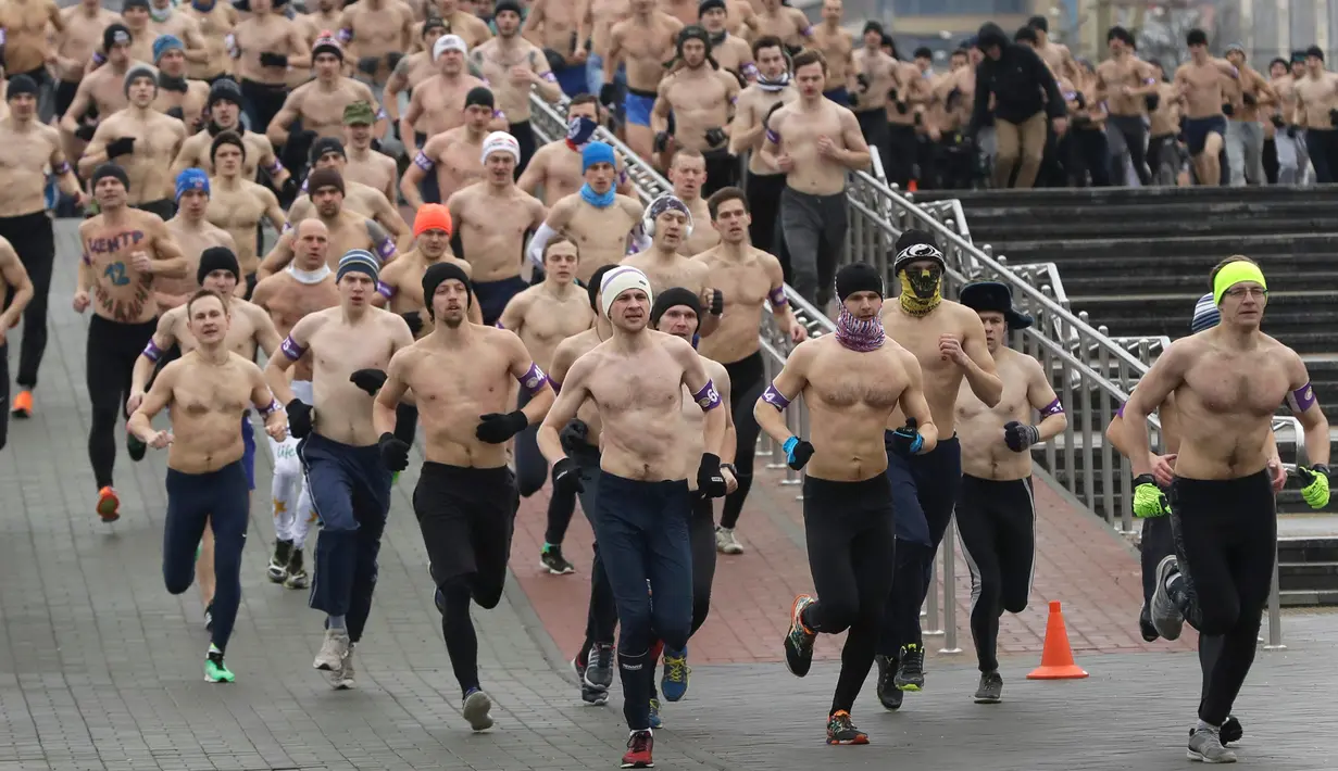 Sejumlah pria berlari dengan setengah telanjang saat berpartisipasi dalam acara "Real men's race" di Minsk, Belarusia, Kamis (23/2). Meski dalam cuaca yang cukup dingin, lomba lari ini mampu menarik partisipasi ratusan peserta. (AP Photo/Sergei Grits)