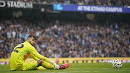 Kiper Arsenal, David Raya, tampak lesu setelah gawangnya dibobol pemain Manchester City, John Stones, pada laga Liga Inggris di Stadion Etihad, Minggu (22/09/2024). (AP Photo/Dave Thompson)
