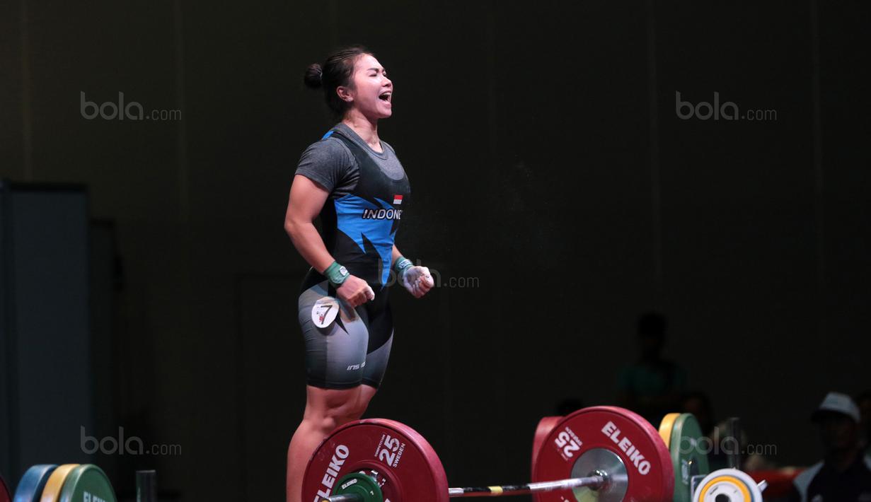 Teriakan Dewi Safitri saat ssebelum mengangkat beban pada kelas 53 kg di Hall A Arena Pekan Raya Jakarta, Kemayoran, Rabu (11/2/2018). Dewi Safitri menang dengan total angkatan 184 kg. (Bola.com/Nicklas Hanoatubun)