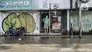 Warga berada di depan toko saat banjir menggenangi Jalan Jatinegara Barat, Jakarta, Senin (8/2/2021). Ketinggian air yang menggenangi Jalan Jatinegara Barat mencapai setinggi paha orang dewasa, sehingga menyebabkan kemacetan. (merdeka.com/Iqbal S. Nugroho)