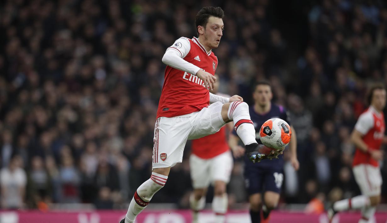 Pemain Arsenal, Mesut Ozil, mengontrol bola saat melawan West Ham United pada laga Liga Inggris di Stadion Emirates, Sabtu, (7/3/2020). (AP Photo/Matt Dunham)