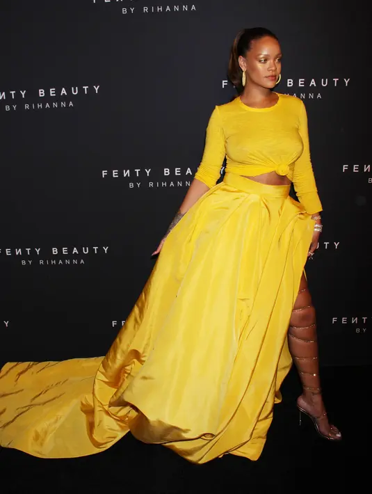 Rihanna berpose untuk fotografer setibanya pada peluncuran Fenty Beauty by Rihanna di Duggal Greenhouse, New York, Kamis (7/9). Rihanna tampil balutan kaus kuning yang dipadukan dengan rok berwarna senada. (Victor Malafronte/STAR MAX/IPx/AP Images)