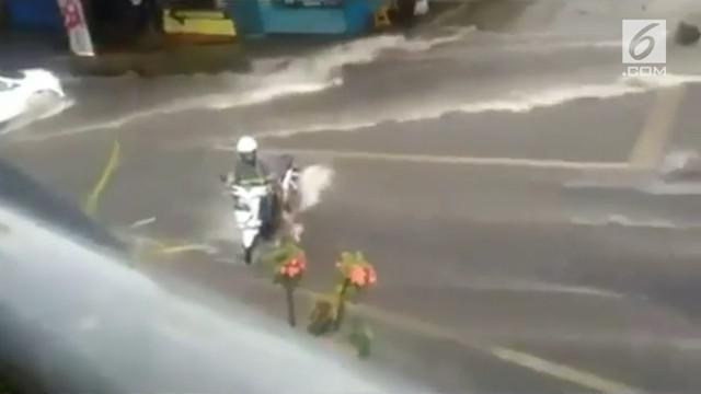 Aksi emak ini bisa dibilang berbahaya. Ia mencoba menerobos banjir dengan sepeda motor hingga terbawa arus.