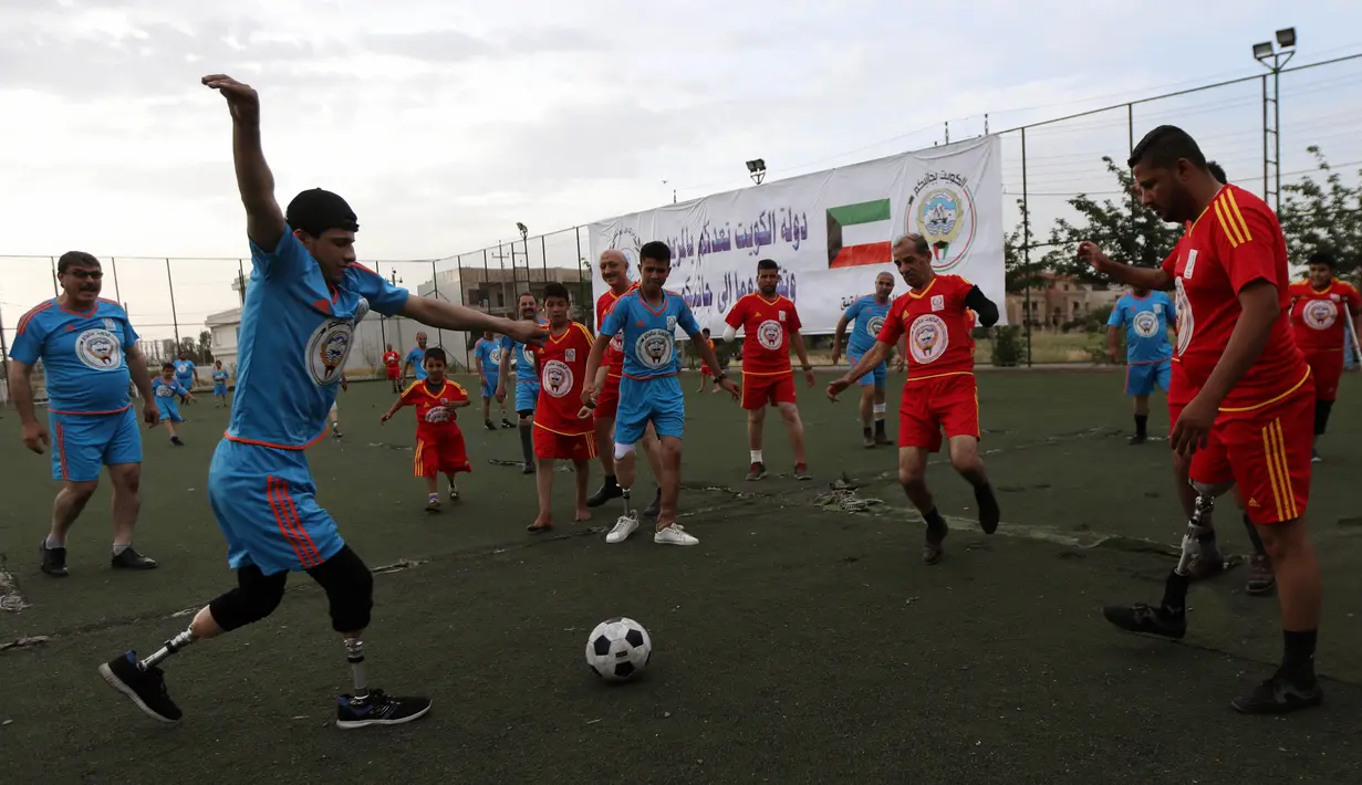 Warga Irak yang kehilangan sebagian anggota tubuhnya bermain sepak bola di Arbil, Irak utara (7/5). Mereka kehilangan sebagian anggota tubuhnya akibat peperangan antara pasukan pemerintah dan ISIS. (AFP/Safin Hamed)