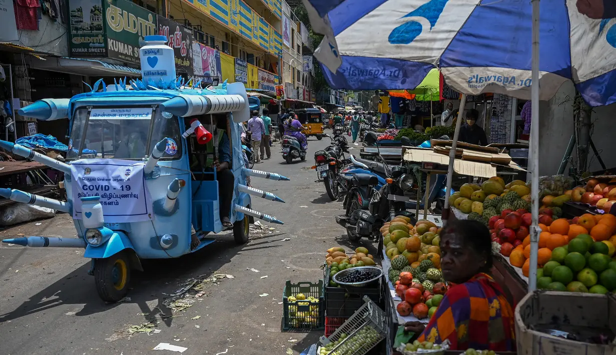 Seorang pekerja kota mengendarai bajaj yang dihiasi dengan jarum suntik tiruan di jalanan di Chennai, India pada Sabtu (3/6/2021). Seorang seniman di Chennai menghias bajaj tersebut untuk meningkatkan kesadaran orang-orang tentang pentingnya vaksinasi Covid-19. (Arun SANKAR/AFP)